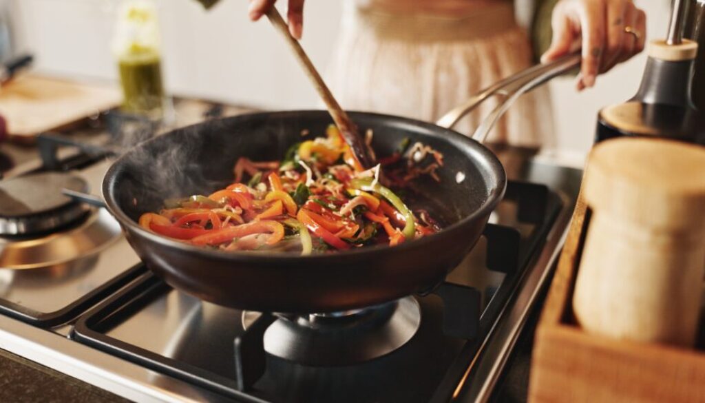 Person,,Cooking,And,Pan,With,Stir,Fry,On,Stove,For