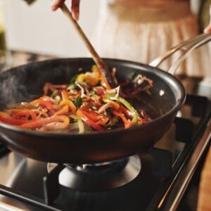 Person,,Cooking,And,Pan,With,Stir,Fry,On,Stove,For